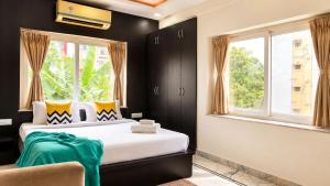 a bedroom with a bed and two windows at BluO Lake View NewTown - Boutique Hotel in Kolkata