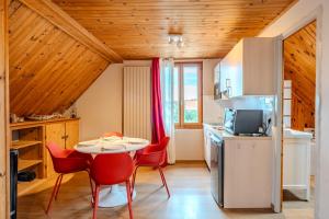 a kitchen with a table and red chairs in a room at RIESLING - Vue imprenable sur le vignoble - rénové récemment - parking gratuit in Riquewihr