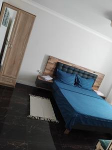 a bedroom with a bed with blue pillows on it at Residence Manu Tg Neamț in Târgu Neamț