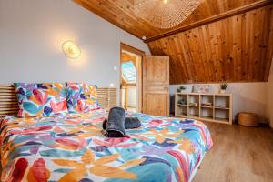a bedroom with a bed with a colorful comforter at RIESLING - Vue imprenable sur le vignoble - rénové récemment - parking gratuit in Riquewihr