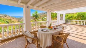 a table on a balcony with a view of the ocean at Elsa Torrox by Ruralidays in Torrox