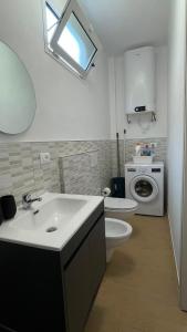 a bathroom with a sink and a toilet and a washing machine at Ca' di Miglietto in Varigotti