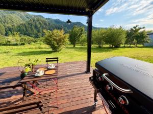 a wooden deck with a table and a grill at 実と來-mitoki in Takayama