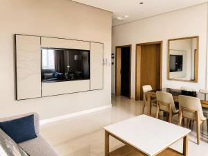 a living room with a table and a tv on the wall at Anisa Residence in Salalah +65 photos