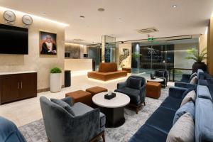 a living room with a blue couch and chairs at Anisa Residence in Salalah