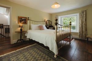 a bedroom with a bed and a window at Cwmalis Hall in Llangollen
