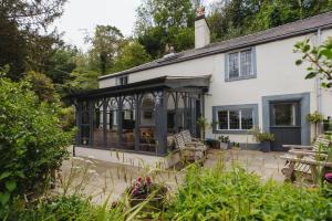 an external view of a house with a conservatory at Cwmalis Hall in Llangollen