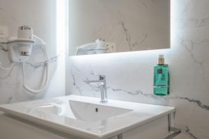 a bathroom with a sink and a green soap bottle at Martin De Aldehuela Apartment in Ronda +17 photos