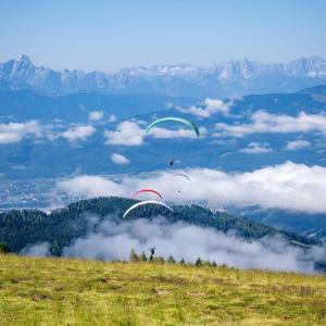 two paragliders are flying over a field of clouds at Apartment-Ferienwohnung 3 Treffen am Ossiachersee in Treffen