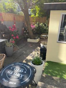 a garden with a sign for a drink out door at Tiny House Beachroom in Scheveningen +1 photo