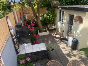 a patio with a table and chairs and flowers at Tiny House Beachroom in Scheveningen