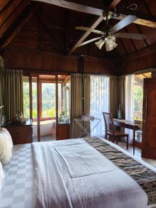 a bedroom with a large bed and a ceiling fan at Aramaya Hills Boutique in Banjar
