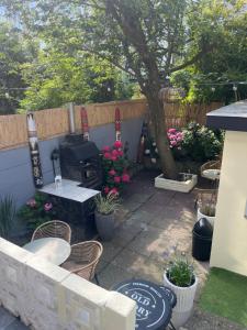 a patio with a grill and chairs and a tree at Beachroom Appartement in Scheveningen