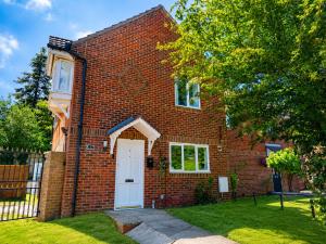 a brick house with a white door in a yard at iblets in Gravesend