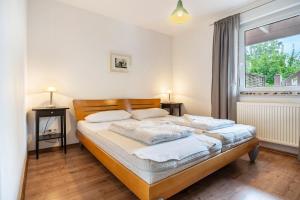 a bedroom with a bed with white sheets and a window at Haus K 104 in Röbel