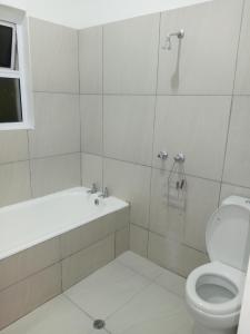 a bathroom with a toilet and a tub and a sink at Chill-Ax Cottages in Port Shepstone +47 photos