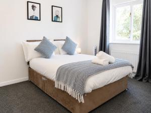a bedroom with a bed with blue pillows and a window at iblets in Gravesend