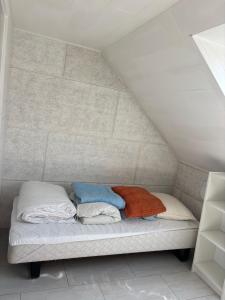 a bed with three pillows on it in a room at Stort byhus i Lemvig in Lemvig +6 photos