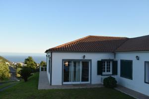 a white house with a view of the ocean at Hydrangea House in Água de Pau
