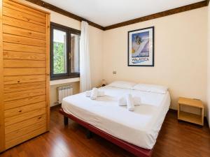 a bedroom with a bed with white sheets and a window at Hostdomus - B4-03 in Grange Sises