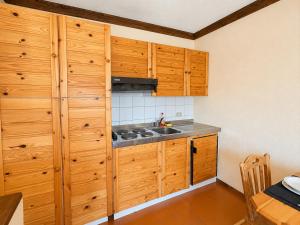 a kitchen with wooden cabinets and a sink at Hostdomus - B4-03 in Grange Sises