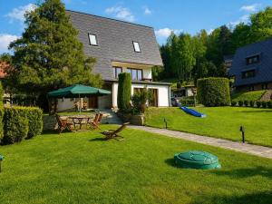 a house with a yard with a picnic table and an umbrella at Dom Wakacyjny Brenna in Brenna