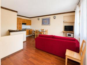 a living room with a red couch and a kitchen at Hostdomus - B4-03 in Grange Sises