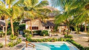 an aerial view of a house with a swimming pool and palm trees at Villa Juliana in Jambiani