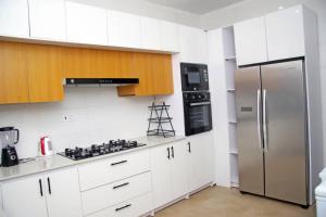 a kitchen with white cabinets and a stainless steel refrigerator at 2 bedroom Apartment Lekki Ovation Terrace and extra room in Lekki