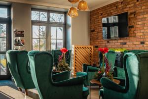 a waiting room with green chairs and a table at Hotel Zamek Gniew in Gniew