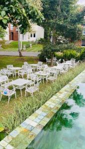 a group of white tables and chairs next to a pool at Prime Lake Villa in Kundasale