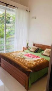 a large bed in a bedroom with a window at Prime Lake Villa in Kundasale +2 photos