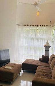a living room with a couch and a window at Prime Lake Villa in Kundasale