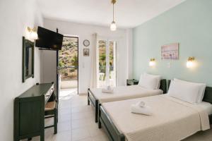 a hotel room with two beds and a television at Villa Zefiros in Kipri