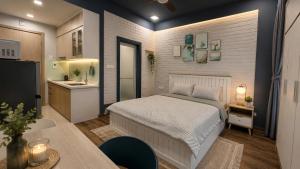 a bedroom with a bed and a kitchen with a sink at JOY APARTMENT TAY HO in Hanoi
