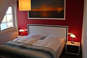 a bedroom with a bed with a red wall at Seestern in Dranske