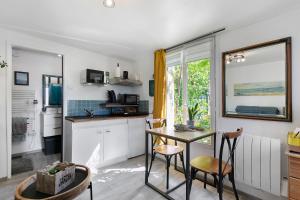 a kitchen with a table and chairs and a window at Le Petit Bécot De Paimpol in Paimpol