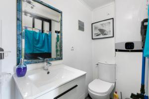 a bathroom with a white sink and a toilet at Le Petit Bécot De Paimpol in Paimpol