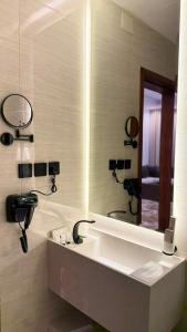a bathroom with a large mirror and a sink at فندق أروف Aroov Hotel in Taif +53 photos