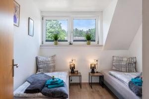 two beds in a small room with two windows at Tanne in Sprakensehl