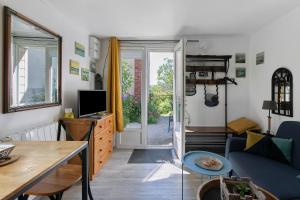 a living room with a couch and a tv at Le Petit Bécot De Paimpol in Paimpol