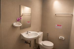 a bathroom with a sink and a toilet and a mirror at Ruen Aiyara Apartment in Nakhon Ratchasima +36 photos