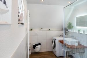 a bathroom with a sink and a washing machine at Tanne in Sprakensehl +20 photos