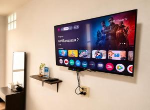 a flat screen tv hanging on a wall at Ruen Aiyara Apartment in Nakhon Ratchasima