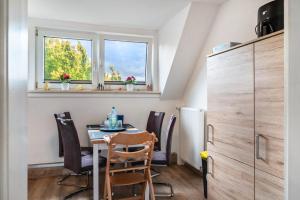 a dining room with a table and chairs and two windows at Tanne in Sprakensehl
