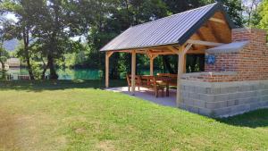 ein Holzpavillon mit einer Bank in einem Park in der Unterkunft Una SI in Lohovo