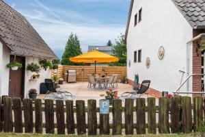 a backyard with a table and chairs and an umbrella at Tanne in Sprakensehl