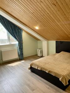 a bedroom with a bed and a wooden ceiling at Tbilisi Vera in Tbilisi City