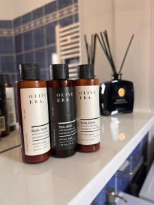 three bottles of hair products sitting on a shelf at Apartman Rosić in Arilje +10 photos