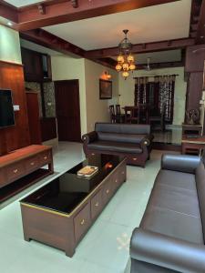 a living room with a couch and a table at Hotel Suncity Villa in Trivandrum